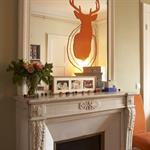 Cheminée classique modernisée grâce à un sticker sur le miroir